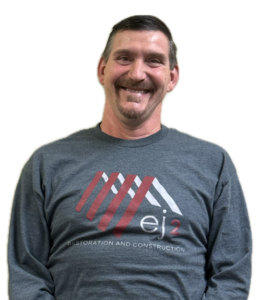 Smiling man wearing a gray long-sleeve shirt with a red and white ej2 logo and the words 'Restoration and Construction'.