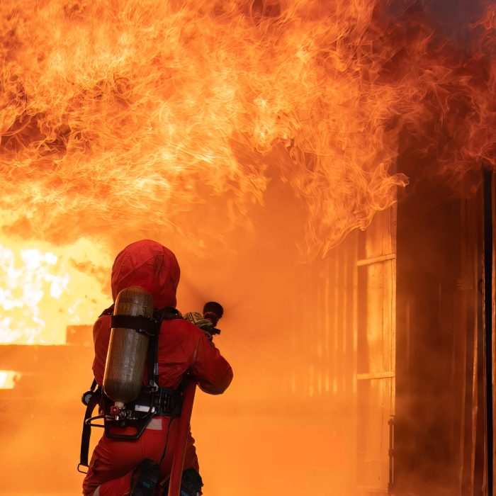 fire fighter team on training fight with massive gas fire by spray jet turbulence water extinguish